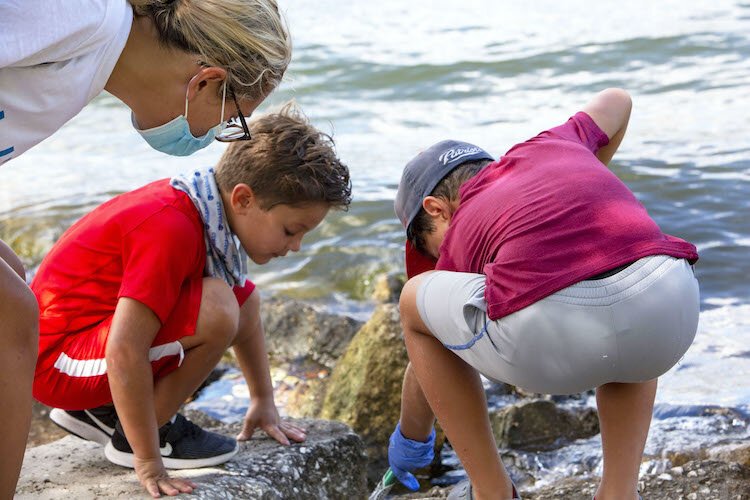 Paul Jacob, 7, tries to reach a bottle cap as his brother, Harrison, 6, and Aunt Jessica Lawson look on.