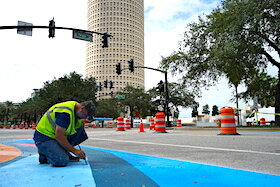 Artists and volunteers help paint portions of Tampa's downtown streets.