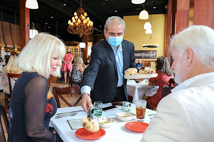 Casa Santo Stefano GM Michael Piazza serves fresh-baked bread to patrons.