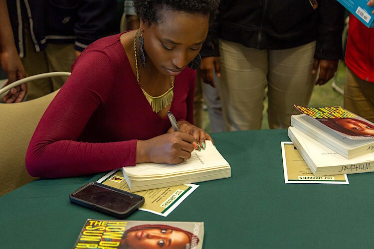 Sandra Uwirigiyimana author of "How Dare the Sun Rise" doing a book signing at the 2020 Books Save Lives award ceremony.