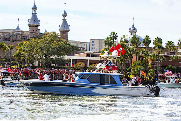 Tampa Bay Buccaneer Coach Bruce Arians waves to fans from the bow of the "Mother May" during Wednesday's boat parade along the Hillsborough River.