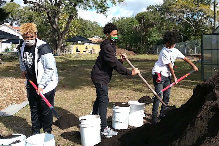 Youth Farm participants Brice Lewis, Aiymere Sanchez, and Shantasia Northern help get the Fresh & Local Greenhouse project ready.