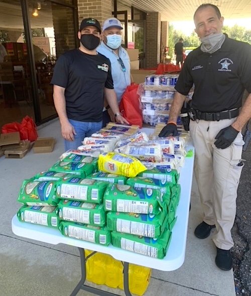 A Hillsborough County sheriff's deputy helps out at the Wholesome Church food bank.