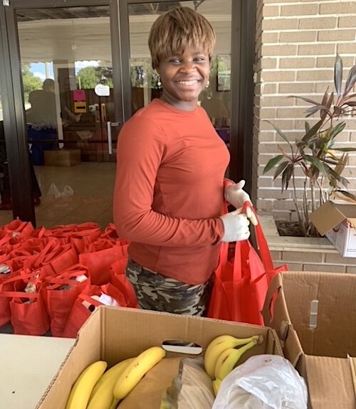 Volunteers prepare bags of food for families in need.