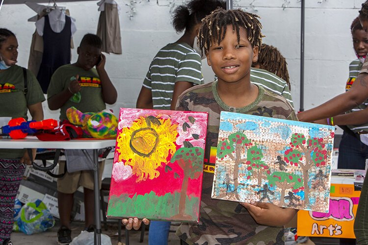Marlyn Lynn, 10, a student at LinaBean Academy, sells his artwork at the Black Business Bus Tour community celebration at Big Al's Finger Licking Good Soul Food.