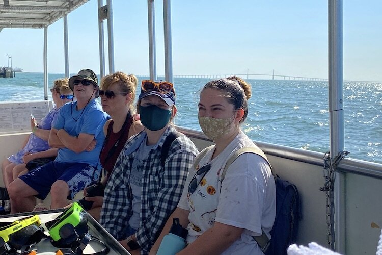 The Skyway Bridge is pictured in the background as USF students boat out to Egmont Key to volunteer in the Sustainable Tourism Development Project.