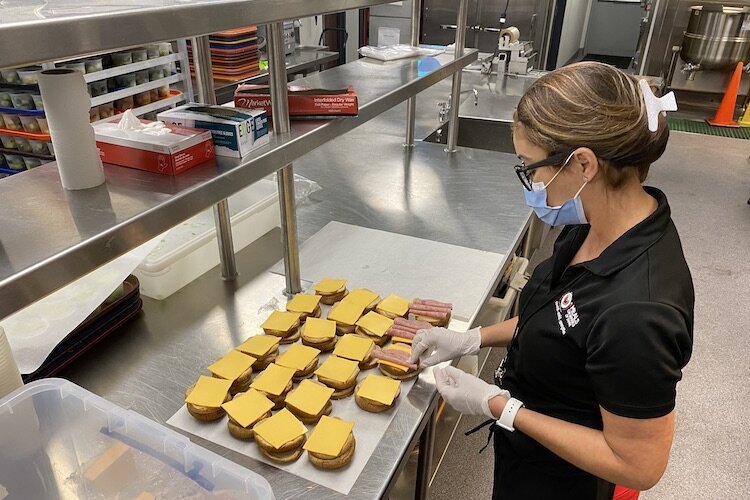 Jese Torres makes meat and cheese sandwiches for Meals on Wheels deliveries to nonprofits that help feed hungry children.