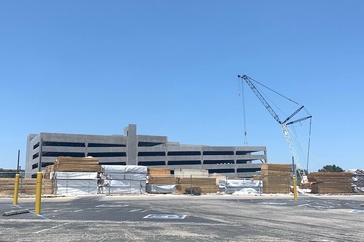 A crane stands sentinel on the east end of the RITHM development to raise a new parking garage in spring 2021.