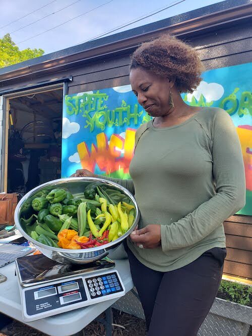 Carla Bristol, St. Pete Youth Farm collaboration manager, shows off some vegetables harvested at the bountiful plot of land on 12th Street in the Midtown district.