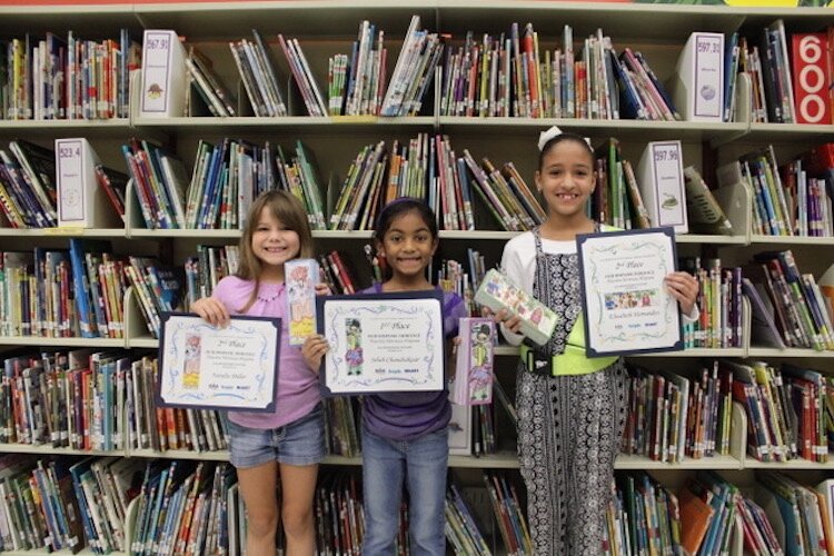Kindergarten to eighth-grade students claim awards for their bookmarks.