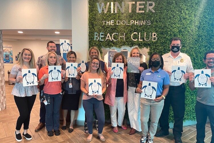 Winter the Dolphin's Beach Club staff celebrating their status as an Ocean Friendly certified business.
