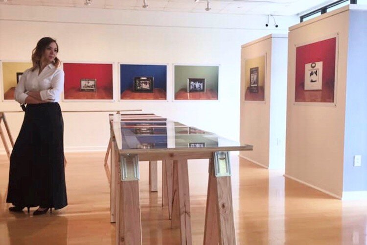 HCC Gallery Director Amanda Poss stands in the installation of " the color of remembering" (2019) by artist Steve Locke in Gallery221@HCC.