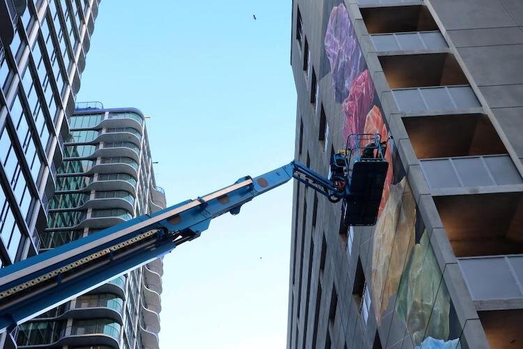 Hovering above the streets, Leon Keer works on his augmented reality mural.