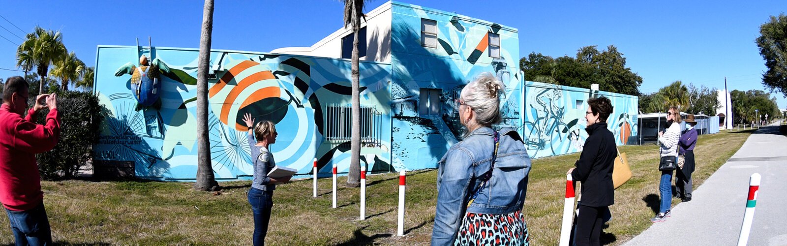 Clearwater Arts Alliance President Roberta Klar gives information about a mural inspired by the history of the region and located by the Pinellas Trail, titled “One Hundred Years Before J Cole” and done by artist duo Michelle Sawyer and Tony Krol.