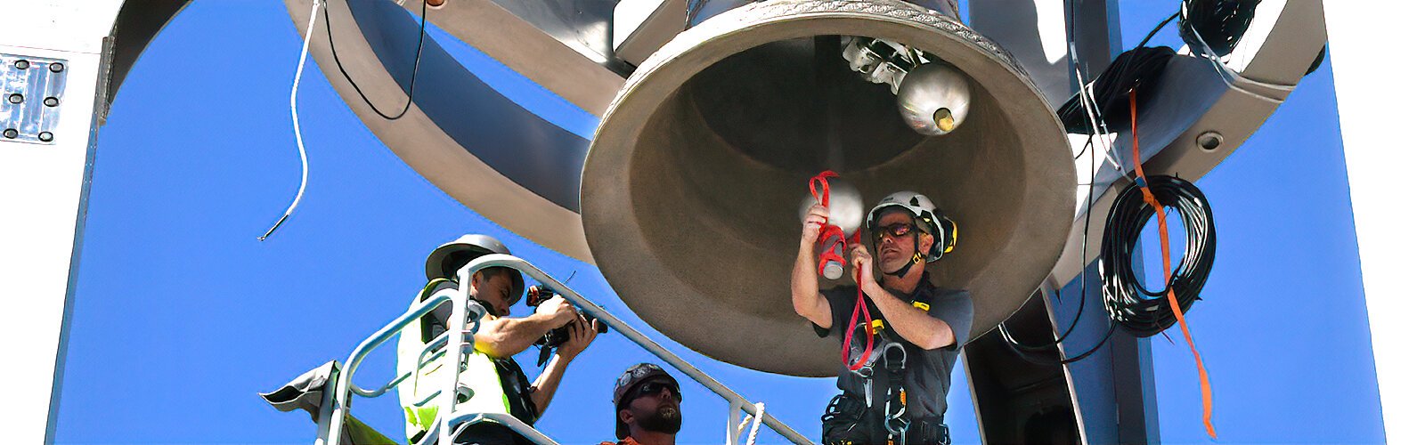 Cyril Paccard temporarily rigs one striker of the Sykes bell with a rope in order to be able to ring it until the cable wiring is done and the bells are electronically connected to a piano keyboard, at which time the rope will no longer be necessary.