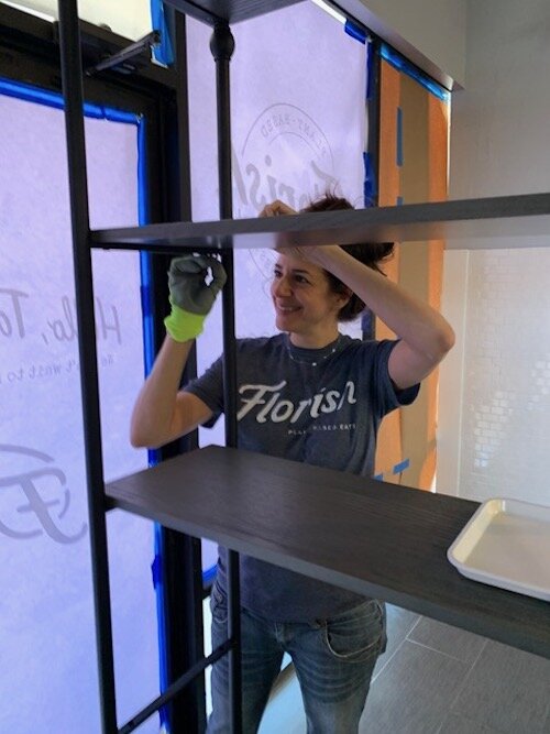 Co-owner Jill Sedita helps install shelving at Florish.