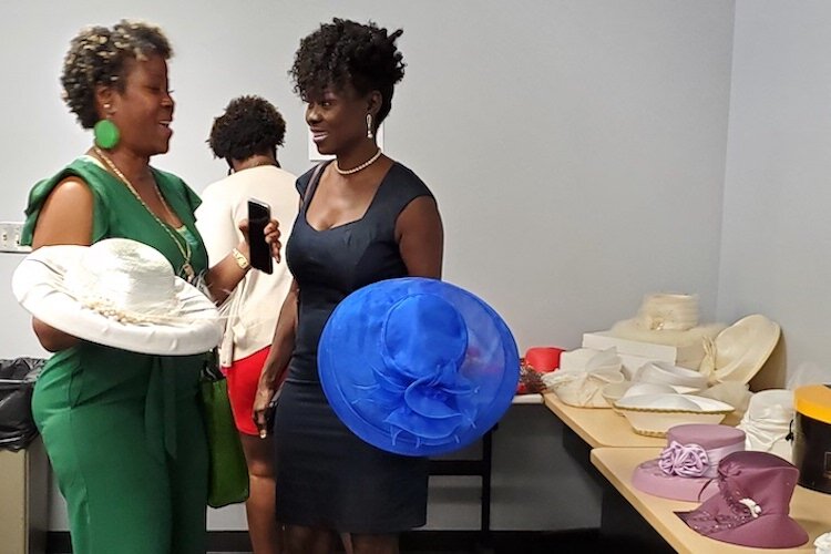 Debora Barr, left, and Twanda Bradley shop for hats after the ceremony to unveil a legacy wall for Chloe Coney. Coney donated hats to raise money for youth programs at the CDC of Tampa.