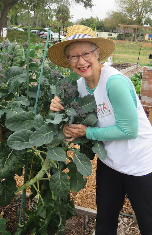 Jennifer Grebenschikoff, President of VISTA Gardens, poses with her prized purple “broccolini” or baby broccoli.