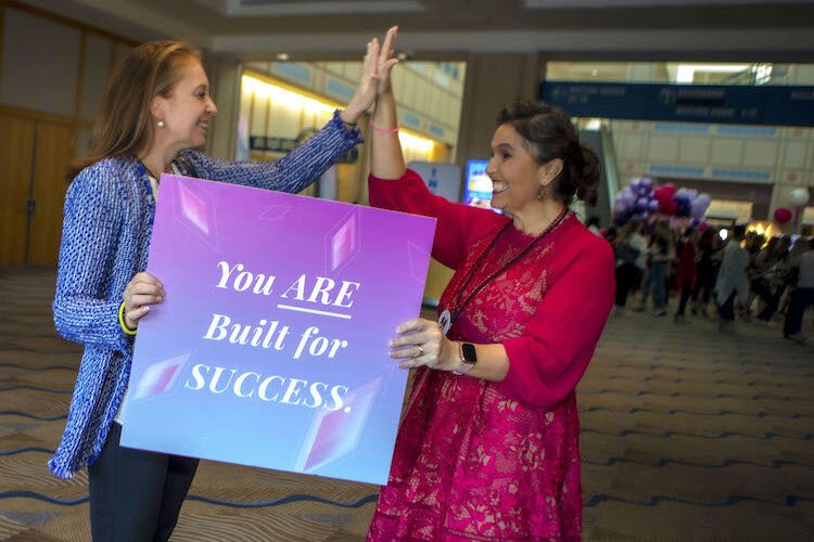 Tampa businesswoman Jen McDonald (L) is greeted by Women's Conference sponsor Rosie Paulsen of RosiePaulsen Enterprises as she enters the Tampa Converntion Center.