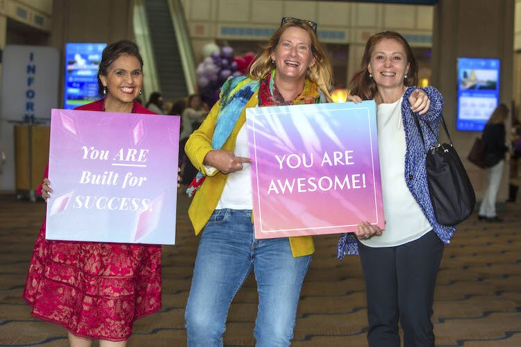 Businesswoman Rosie Paulsen (L) and volunteer Krista Capo (C) pose with Tampa businesswoman Jen McDonald at the Convention Center entrance.