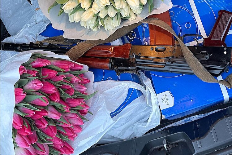 Flowers for International Women's Day next to a rifle in a car trunk -- a sad commentary on everyday life in Ukraine.
