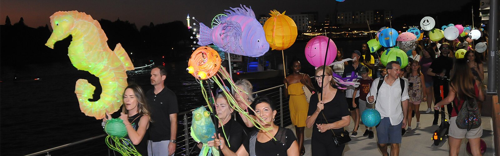 The Riverfest Lantern Parade moves along the Tampa Riverwalk Saturday night.