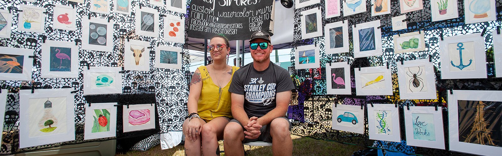 Brianne and Tommy Roberts rest as they wait for another customer at their display “Key Strokes” at The Market Marie in Clearwater on Saturday. Brianne's watercolor art covers a variety of subjects.