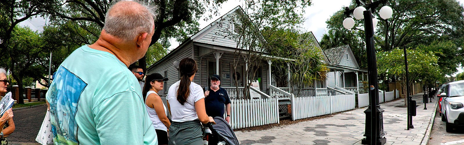 Tour participants view a row of restored casitas. Initiated in 1885, this was the lodging style of the era and these small houses were the homes of cigar workers. 