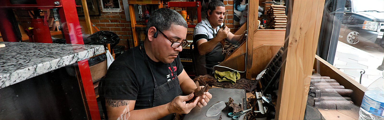 Two cigar workers can be seen through the window, rolling cigars at La Faraona Cigars in Ybor City. At the end of the 19th century, some 500,000 cigars were rolled per month in the first Sanchez y Haya factory.