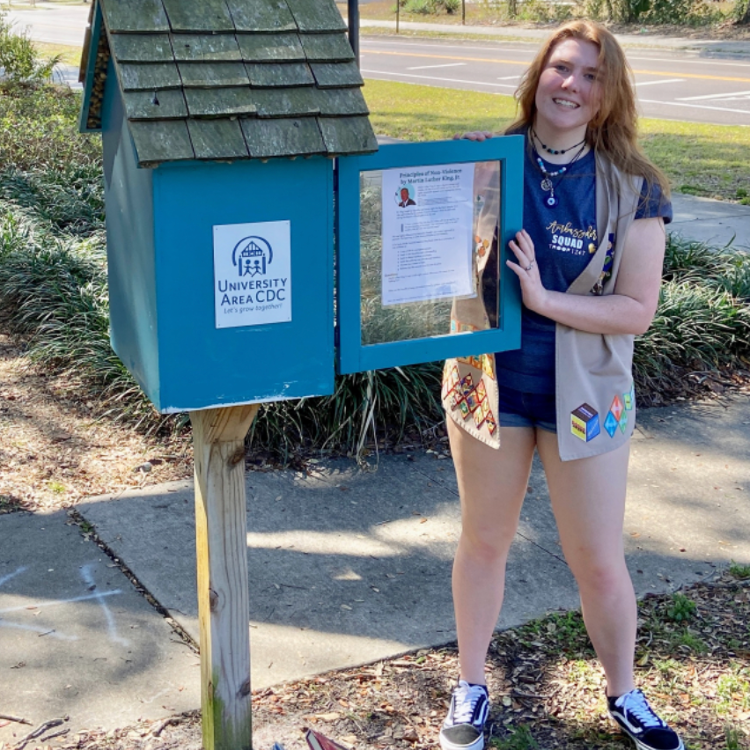 Elaine Feaster stocks a little free library box with books collected during a donation drive she organized.