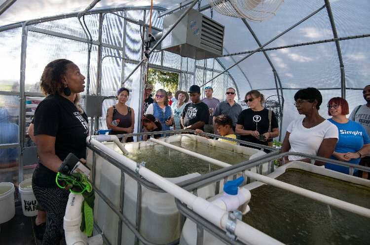 Carla Barton, the collaboration manager for the St. Pete Youth Farm, leads a tour of the urban farm's new greenhouse.