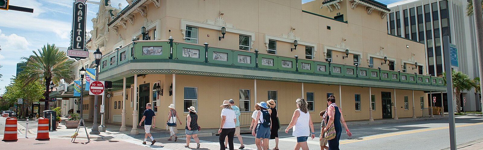 The Clearwater Arts Alliance's downtown Public Art Walk tour group crosses the street under the Capitol Theatre’s stainless steel frieze by artist Darin Evans titled “The Big Ticket.”