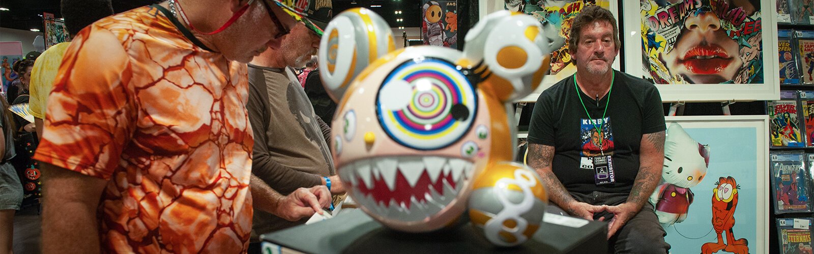 Exhibitor David Richard with End to End Gallery, waits as customers browse comic books at the Tampa Bay Comic Con. The fine art sculpture in the middle is by artist Takashi Murakami and is titled “Mr. Dob."