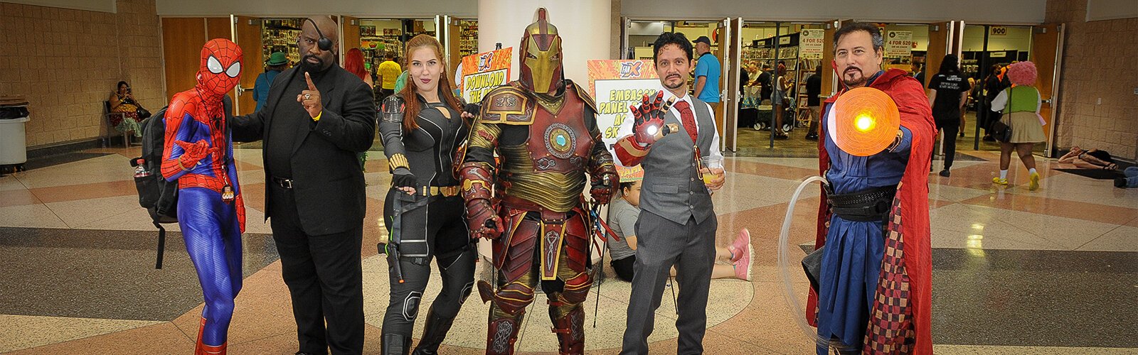 A group of attendees at the Tampa Bay Comic Con pose outside the exhibit hall at the Tampa Convention Center for a photo.
