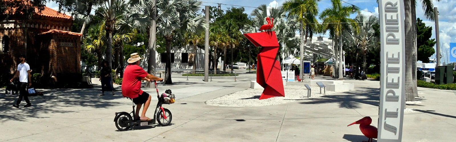  A visitor with a pooch in basket is greeted at the entrance of the St Pete Pier by the red pelicans from Nathan Mabry’s artwork “Myth." The pelican was declared St Petersburg’s official bird in 2020.