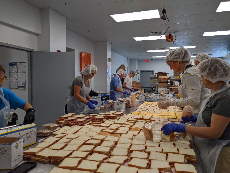 Volunteers from World Central Kitchen and the Tampa Bay area prepare sandwiches in Metropolitan Ministries' Tampa kitchen.