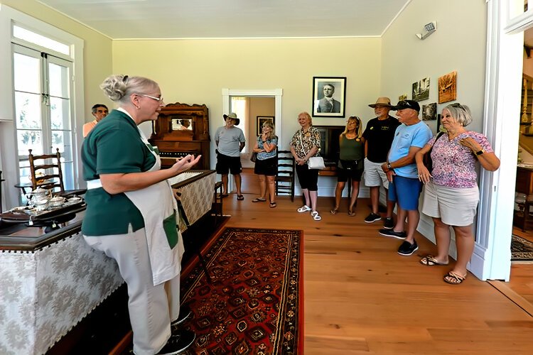  Ray and Karen Hyde, at right, and other visitors listen to docent Deborah Charlow during a guided tour of the historic house.