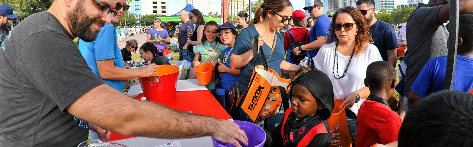 Children receive candies at the booth of the Covenant Life Church, one of more than 50 treat stations participating in the event along the Riverwalk.