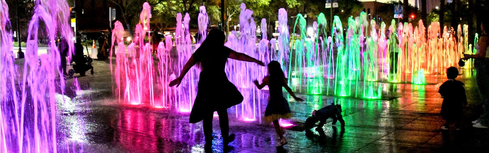 Colorfully lit in the evening, the splash pad at Curtis Hixon Waterfront Park entices families to continue celebrating the spooky season and run through the splashing water jets. 