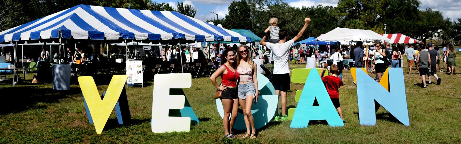 Happy and proud to be vegan, people pose on both sides of the "VEGAN" letters of the 11th Annual Tampa Bay VegFest at Perry Harvey Sr. Park in Tampa, Saturday, November 5th.