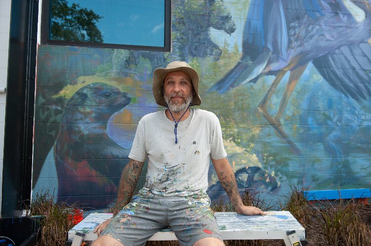  Ernesto Maranje in front of his mural at the Florida Wildlife Corridor Foundation office in St. Petersburg.