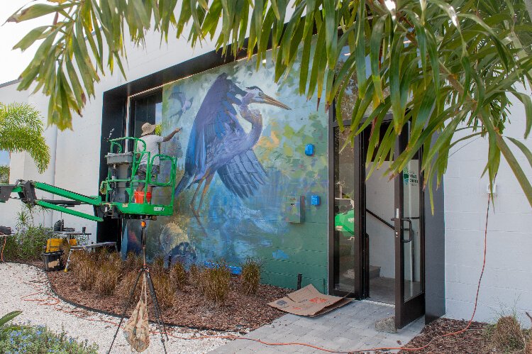 Artist Ernesto Maranje paints a mural on the offices of the Florida Wildlife Foundation Corridor at The Factory, St. Pete.