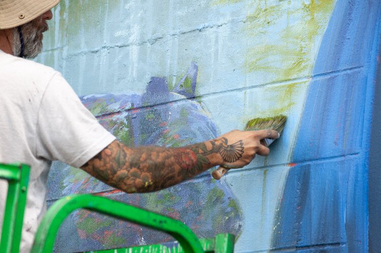Ernesto Maranje paints on the wall mural he created at the Florida Wildlife Corridor Foundation office in St. Petersburg.
