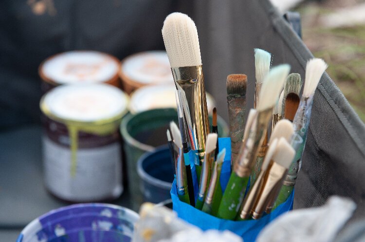 Artist Ernesto Maranje keeps his supplies and tools close as he works on a wall mural at the Florida Wildlife Corridor Foundation office.