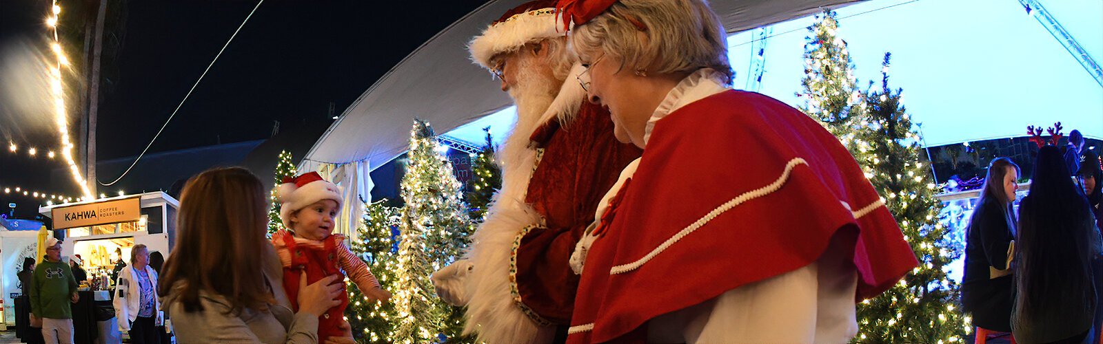 All donned-up for her first Christmas, ten-month-old Ella meets Santa and Mrs. Claus during a Santa Sighting at the Winter Village.