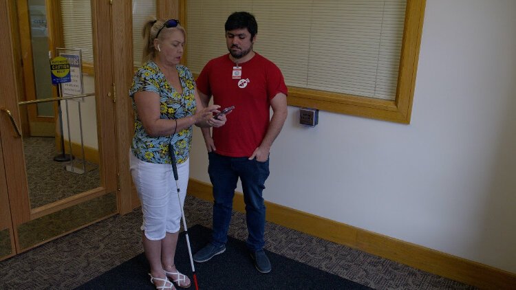 Tampa resident Janet Bayer demonstrates the Lazarillo app inside Old City Hall.