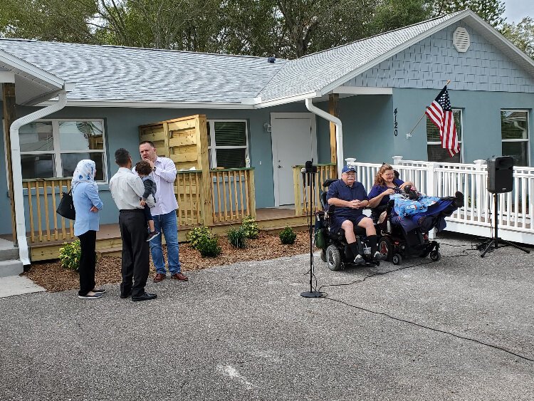 Mike Sutton, president of Habitat for Humanity of Pinellas and West Pasco Counties, chats with the Al-Rubaye/Qasim family while Paula and James Diviney wait for the dedication ceremony to begin.