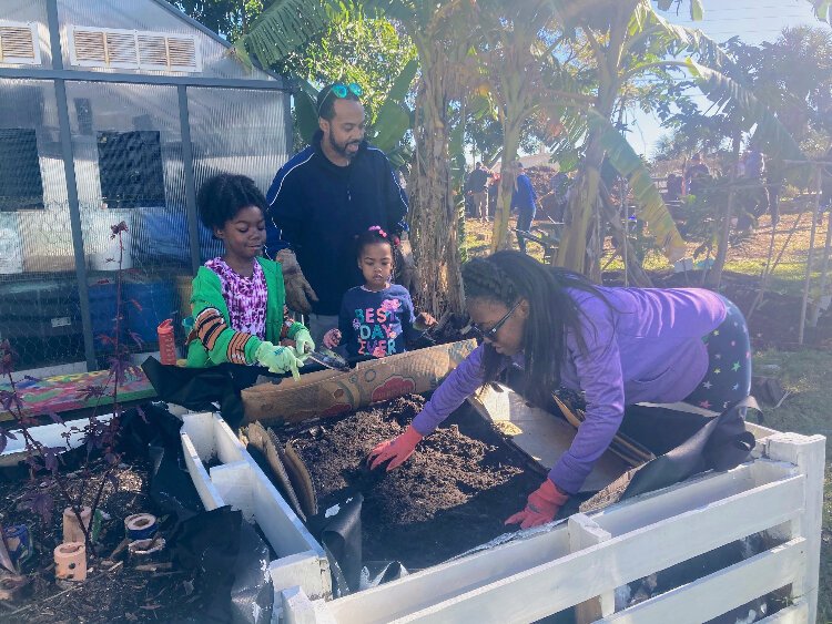 Rodrique Rodney and his three daughters volunteer at the St. Pete Youth Farm during the MLK Day of Service.