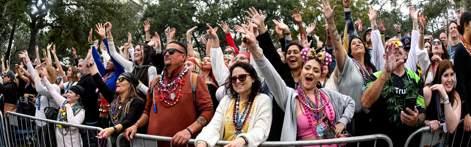 Parade goers beg excitingly for beads on Bayshore Boulevard during the 106th Gasparilla parade of pirates in Tampa.