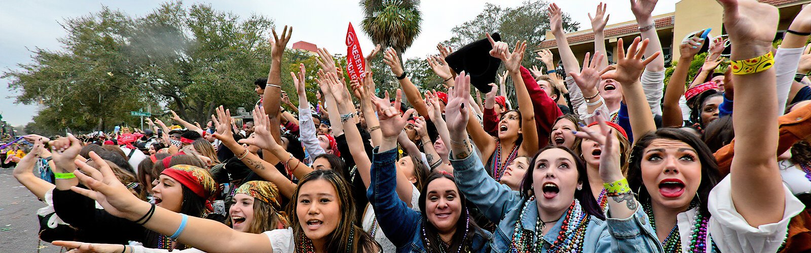 Eager hands reach out for the beads, coins, and other Gasparilla treasures tossed out by the pirates along Bayshore Boulevard.